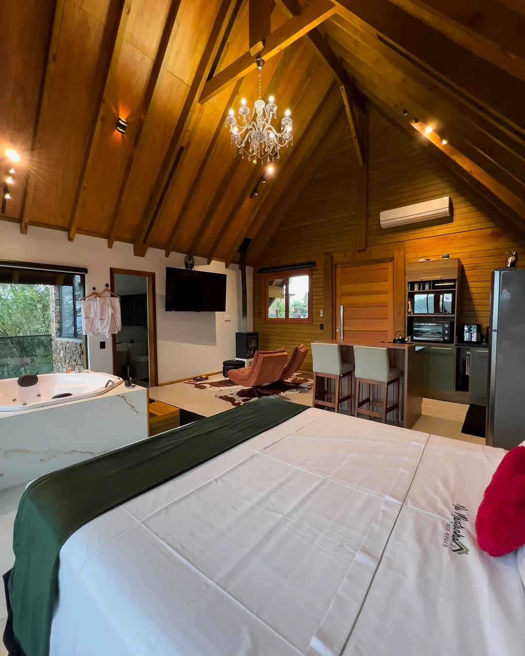 Cabana da Pedra — cama sob o teto de madeira, com vista